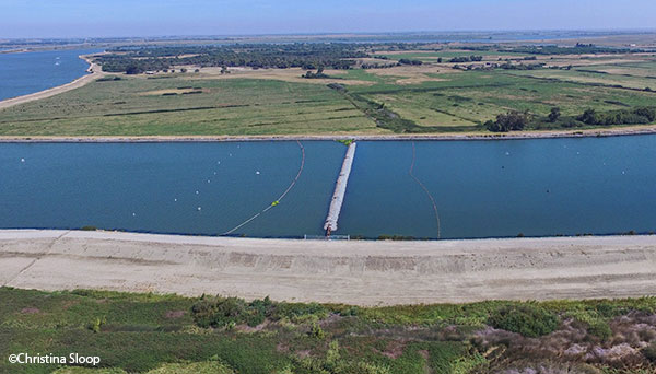 aerial view of barrier stretched across water channel