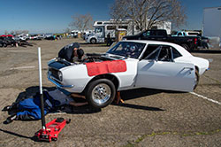 Scientist Ben Ewing's hobby is working on a white Chevy Camaro car in a parking lot