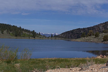 small alpine lake surrounded by mountain peaks