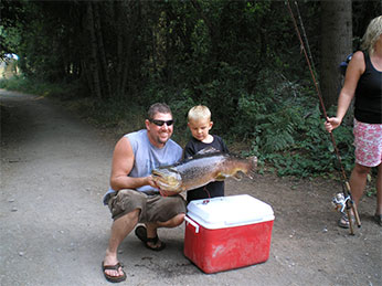 A young angler helps hold his catch of the day