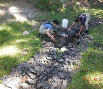 two men working in rocky streambed