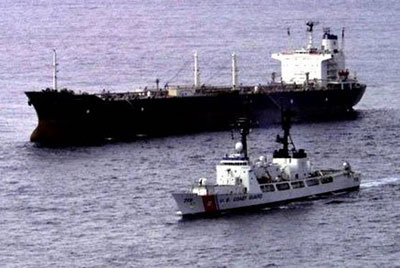 tanker being escoretd by a US Coast Guard boat
