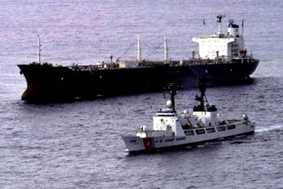 Anoil tanker being escoretd by a US Coast Guard Cutter